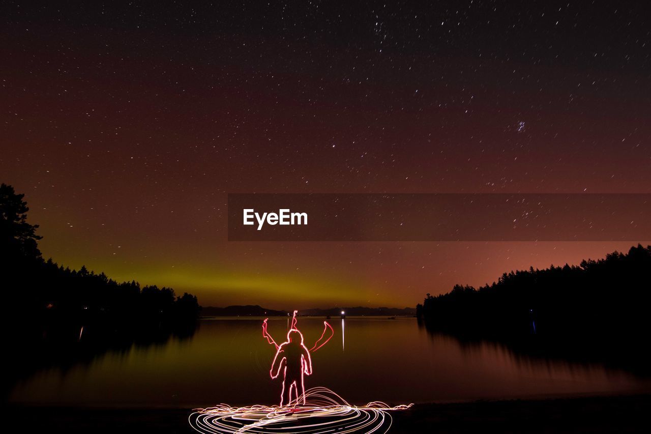 Light painting by lake against star field at night