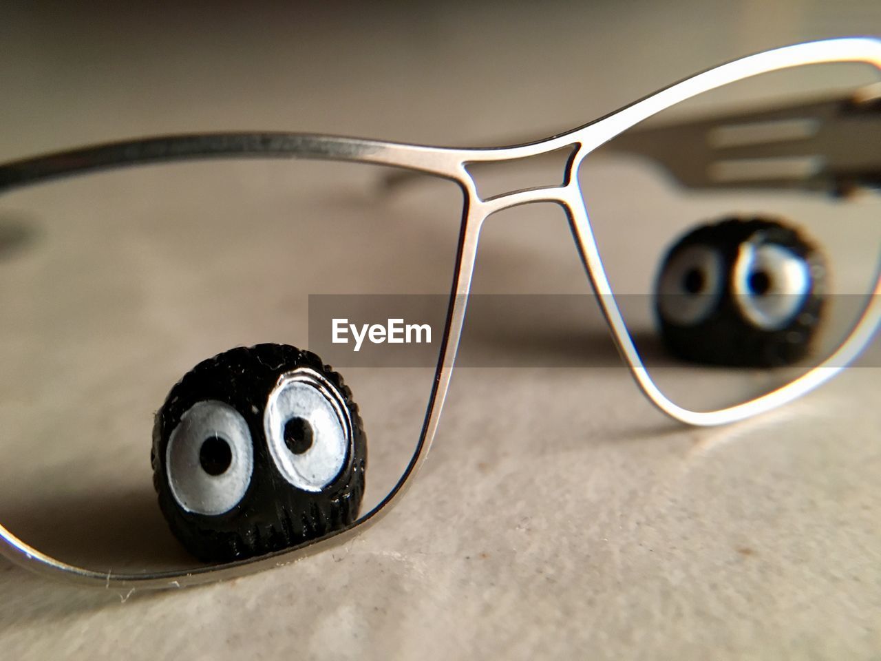 CLOSE-UP OF EYEGLASSES ON METAL TABLE