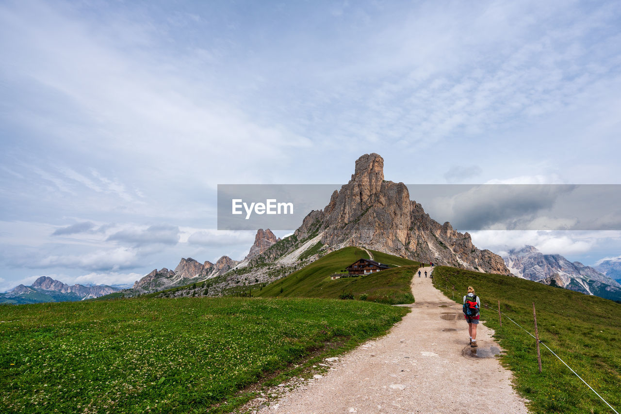 Rear view of woman walking on mountain against sky