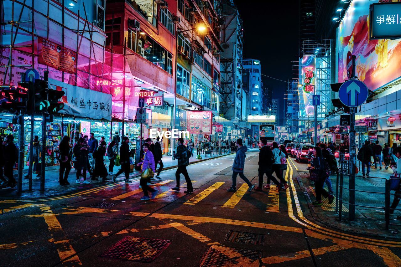 People walking on city street at night