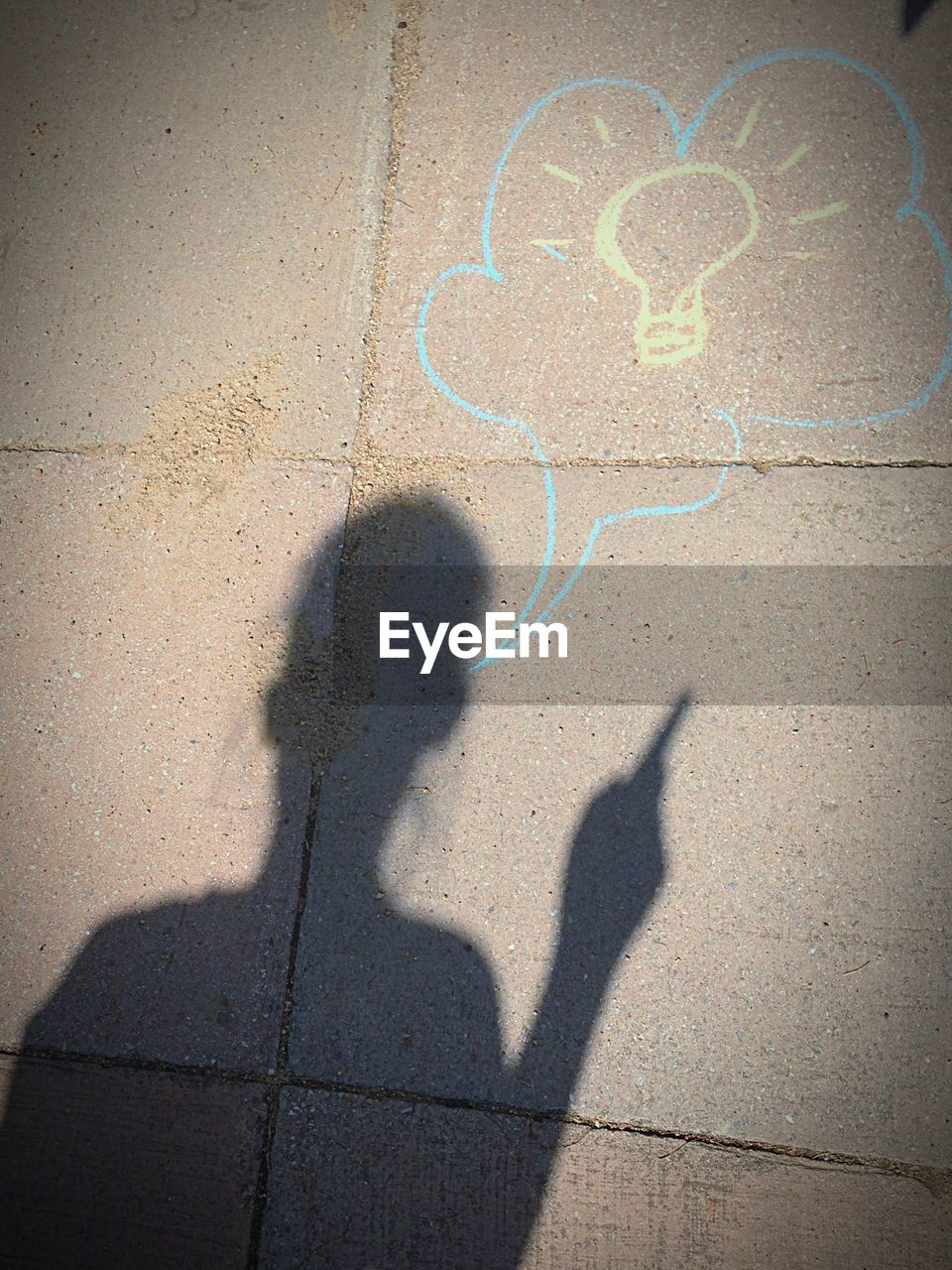 Optical illusion of man shadow with thought bubble on sidewalk