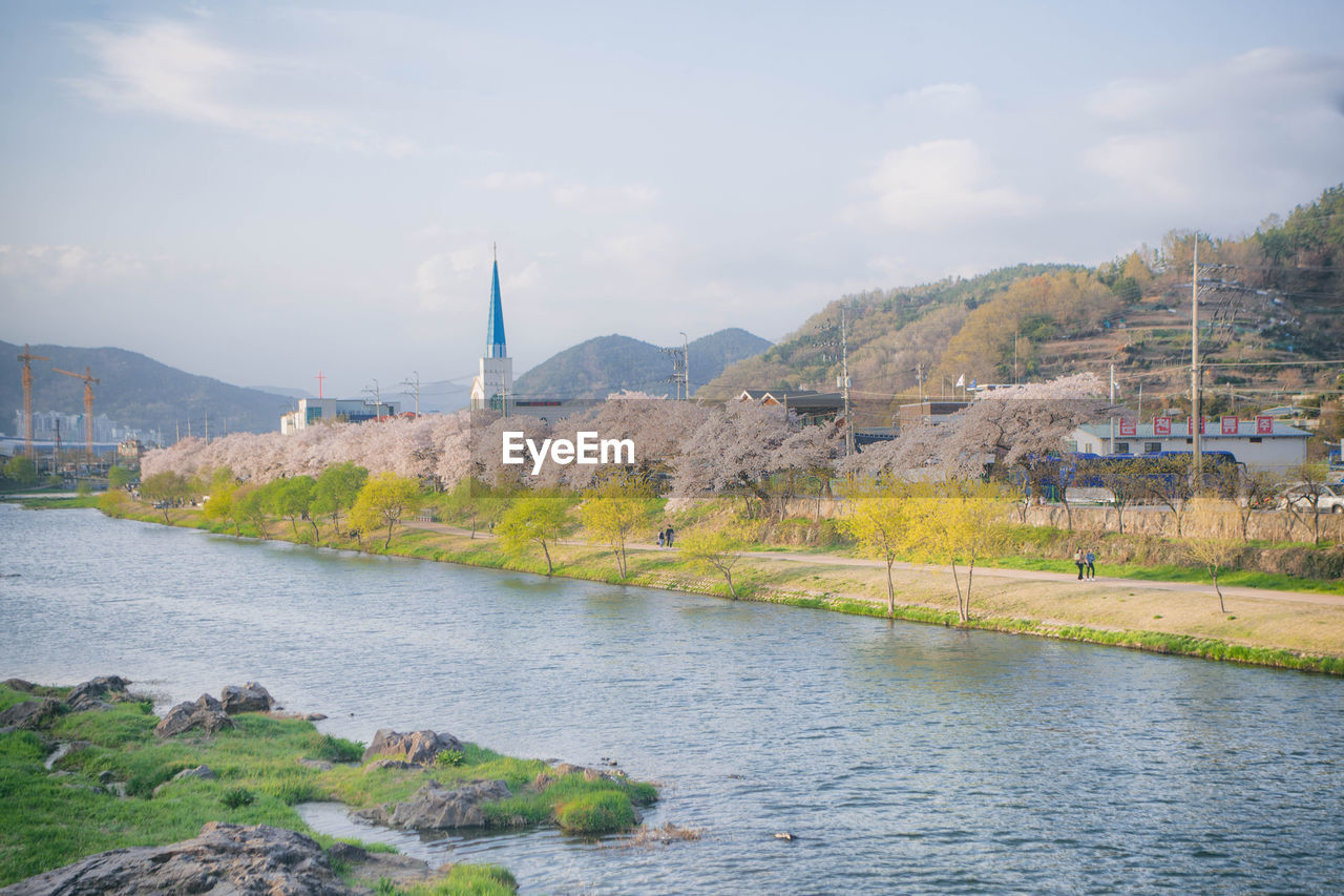 SCENIC VIEW OF RIVER AMIDST BUILDINGS AGAINST SKY