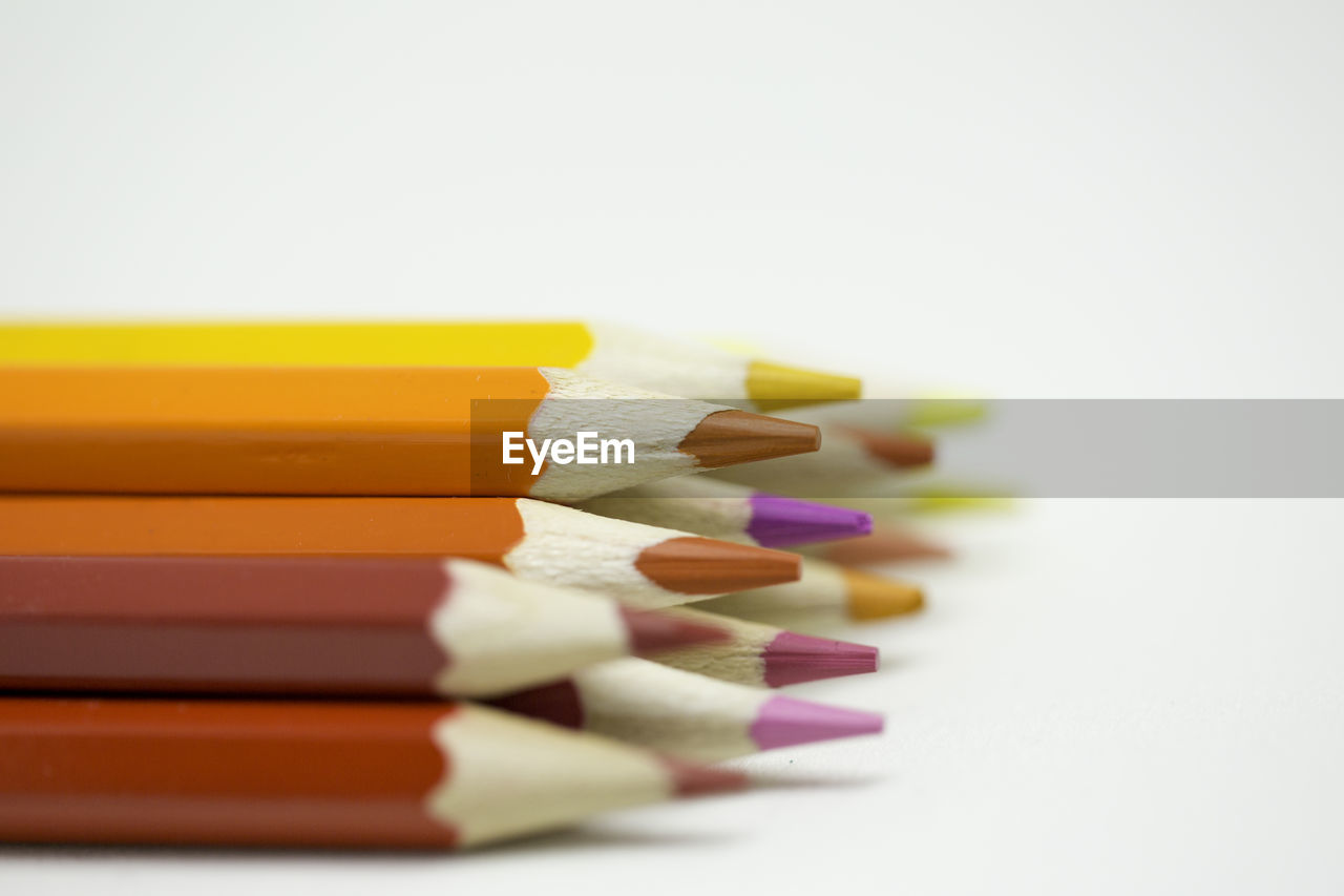 Close-up of colored pencils over white background