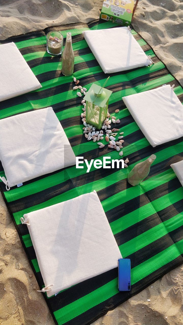 HIGH ANGLE VIEW OF OPEN BOOK ON TABLE BY POTTED PLANT