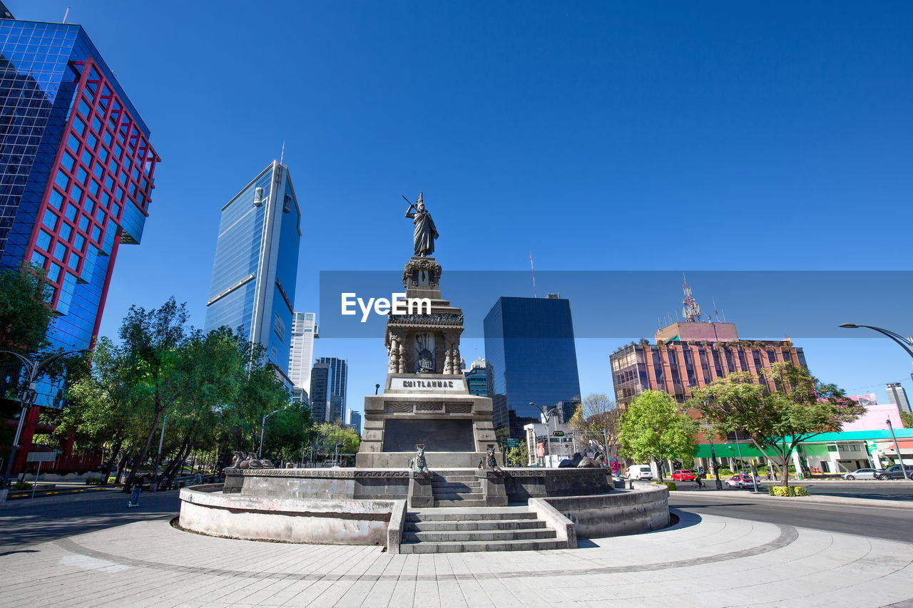 STATUE OF BUILDINGS AGAINST CLEAR BLUE SKY