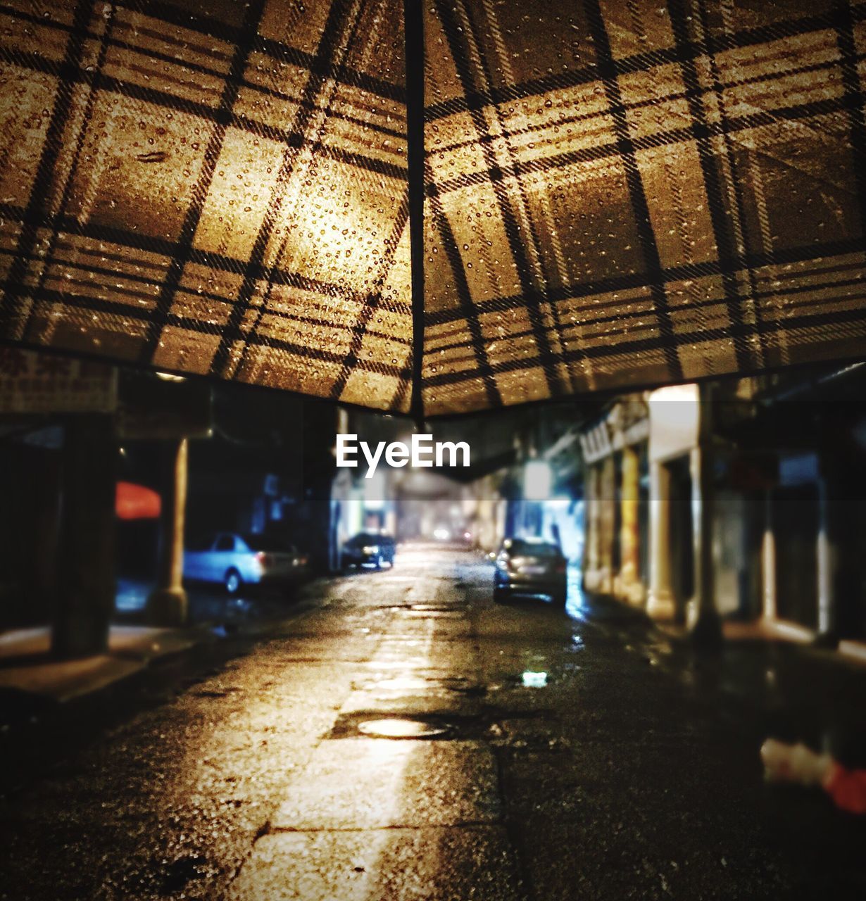 Brown umbrella next to road at night