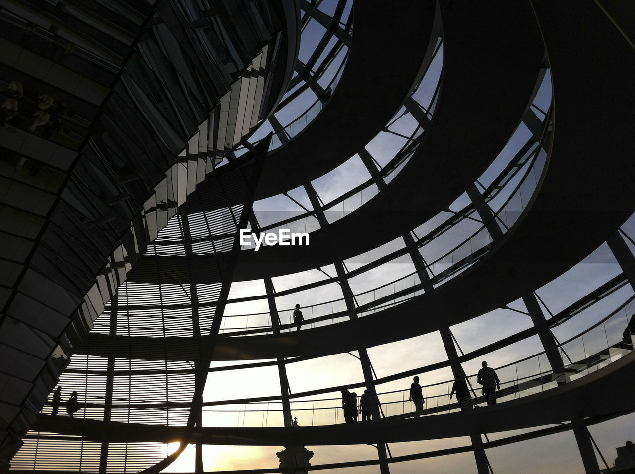 Low angle view of people walking in reichstag at sunset