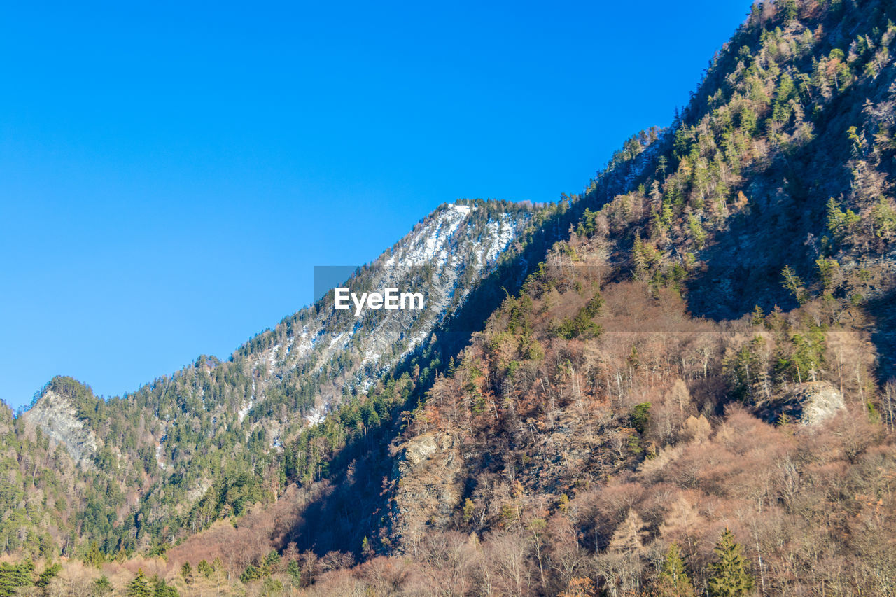 Low angle view of mountain against clear blue sky