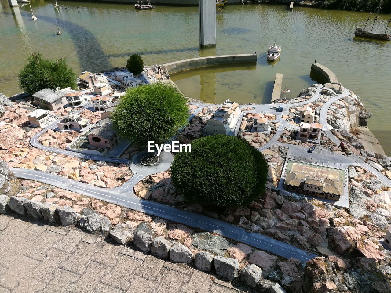 HIGH ANGLE VIEW OF PLANTS BY LAKE AGAINST TREES