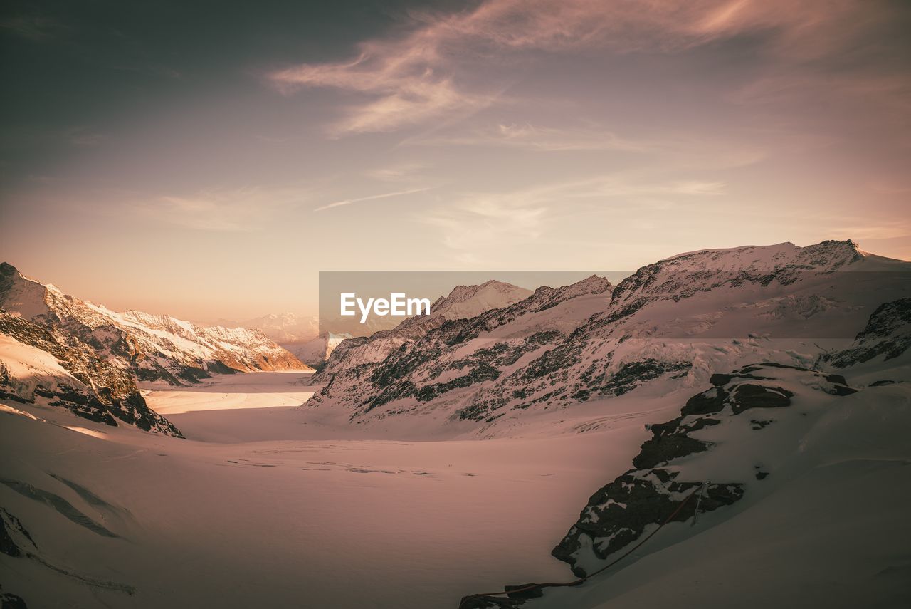Scenic view of snowcapped mountains against sky during sunset
