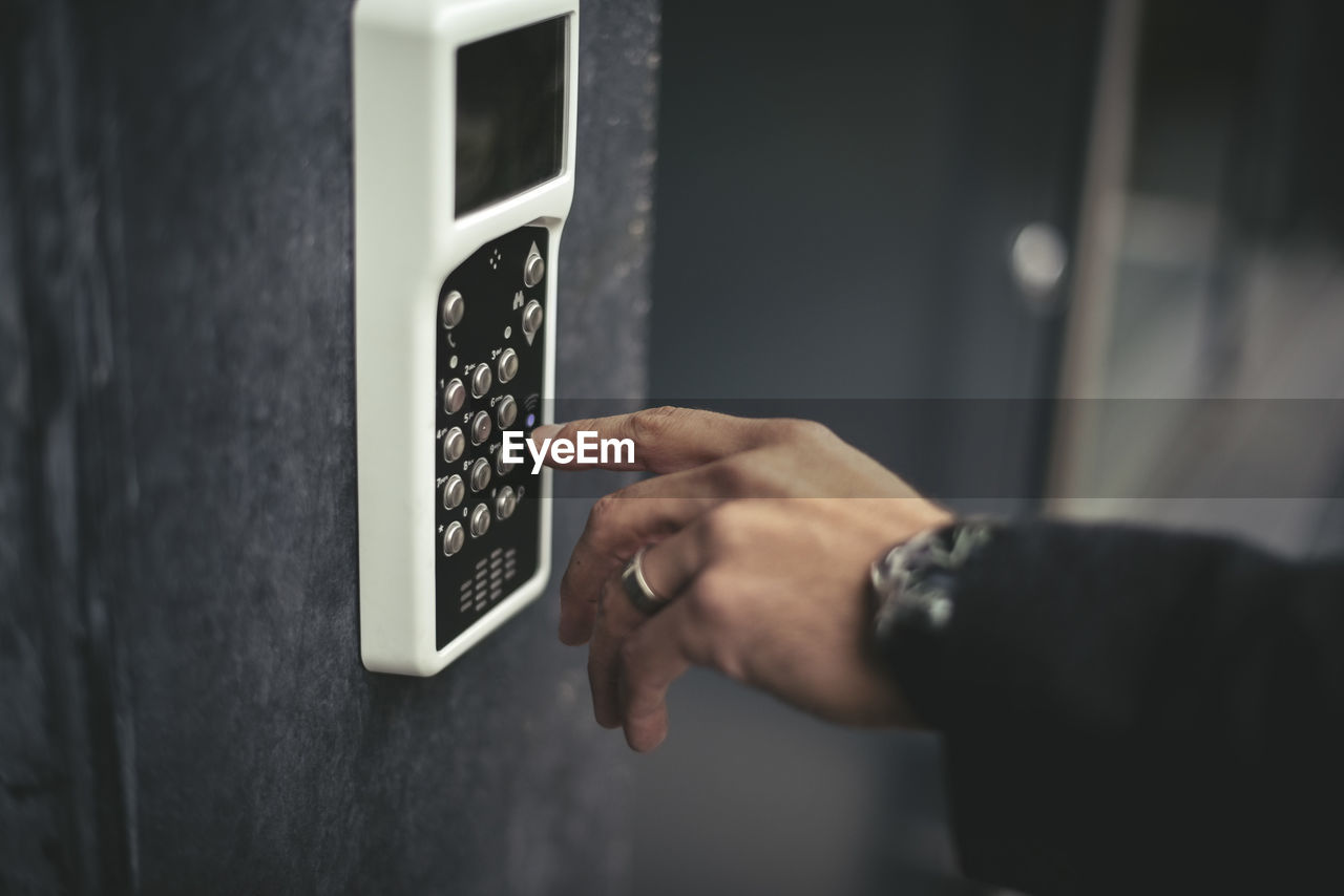 Cropped image of businessman's hand entering keycode