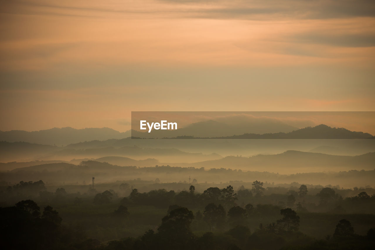 Scenic view of silhouette mountains against orange sky