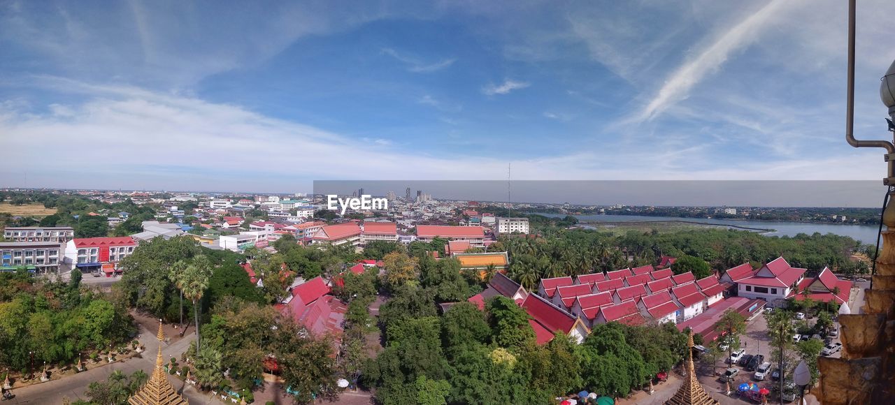 HIGH ANGLE VIEW OF TOWNSCAPE AND TREES AGAINST SKY