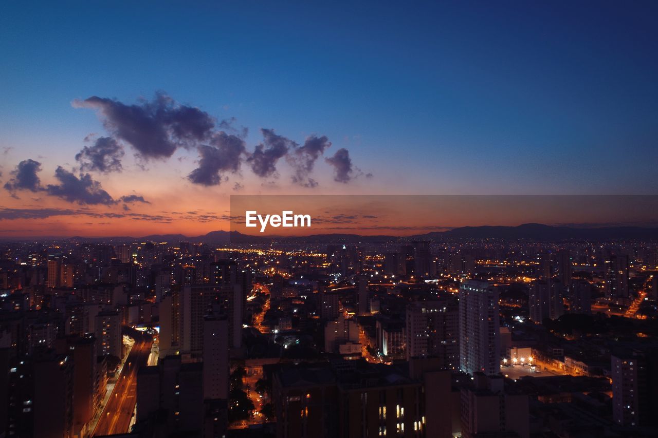 Illuminated cityscape against sky at night