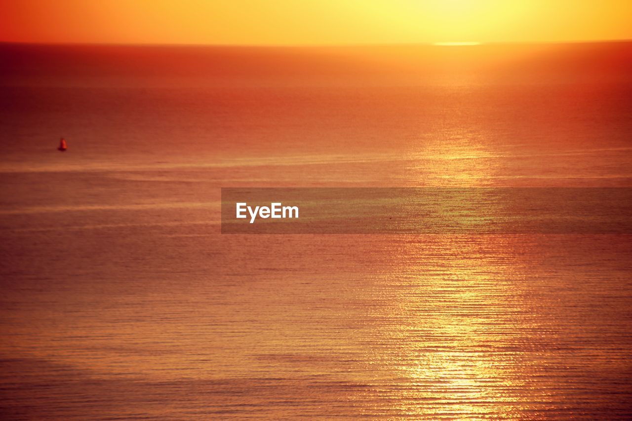 Scenic view of sea against orange sky