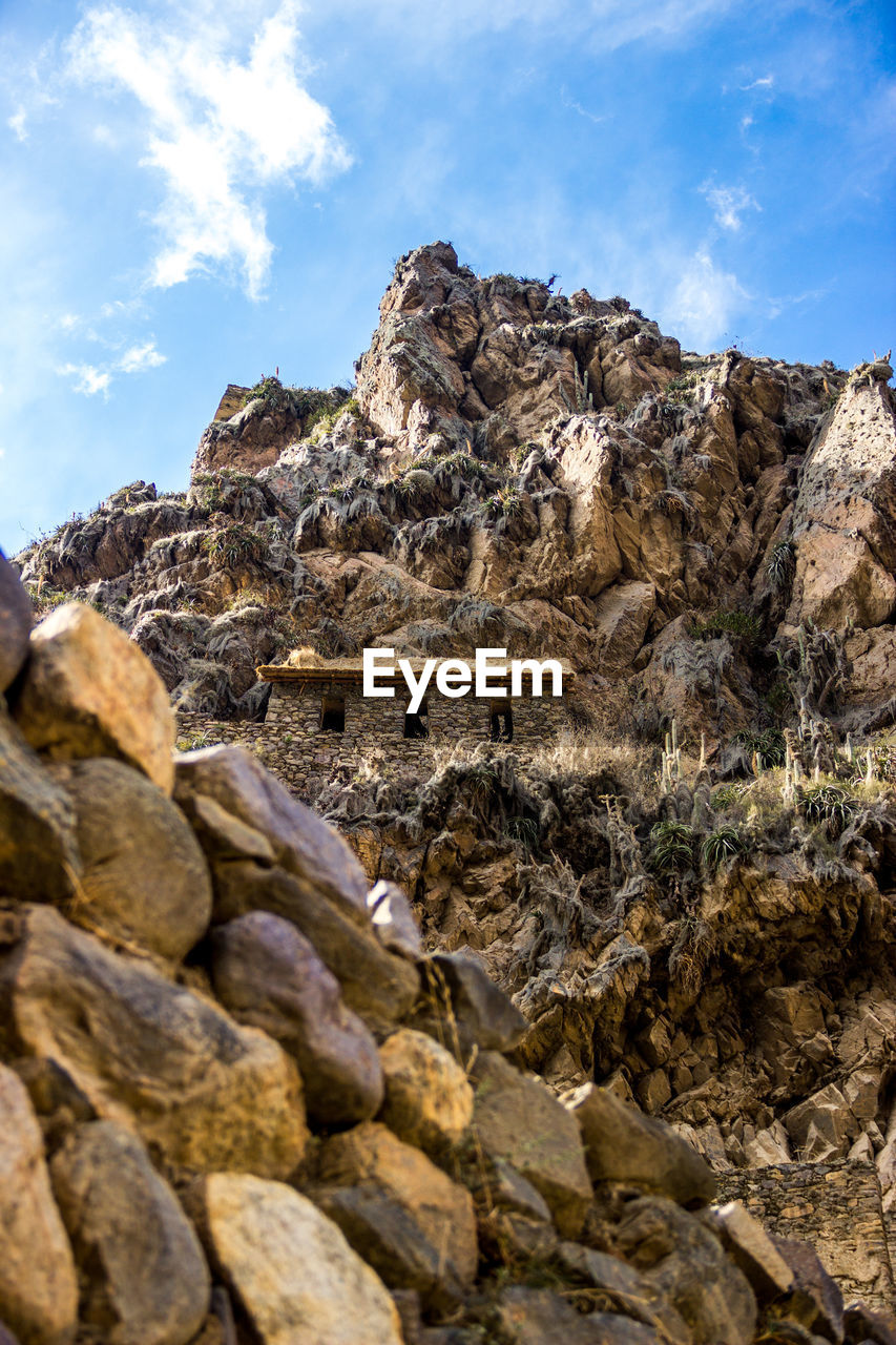 LOW ANGLE VIEW OF ROCK FORMATION ON MOUNTAIN AGAINST SKY