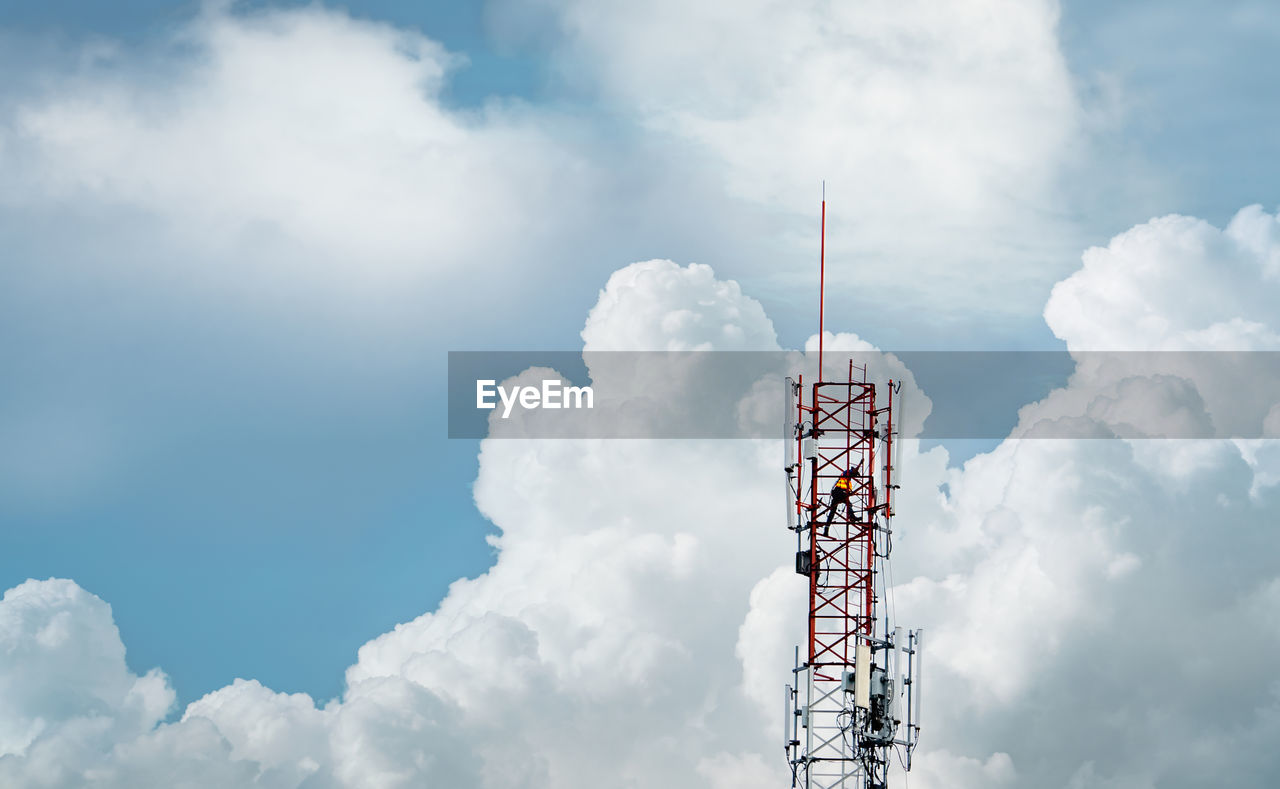 Telecommunication tower with blue sky and white clouds. worker installed 5g equipment.