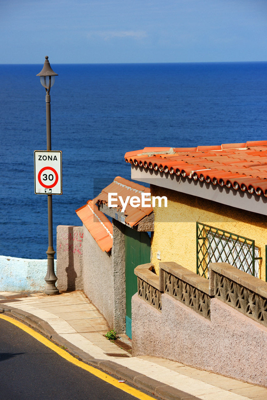 Houses against seascape on sunny day