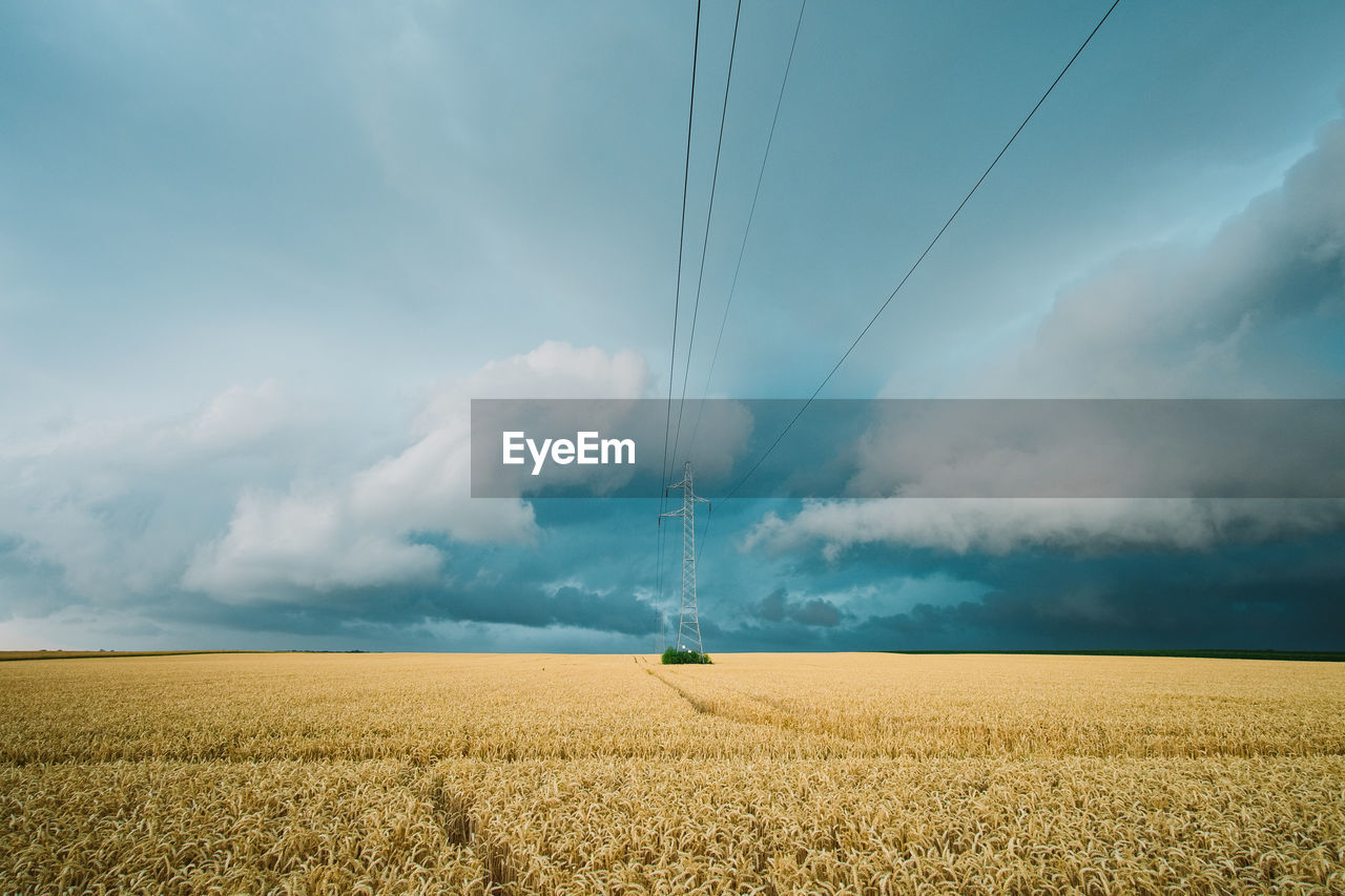 Scenic view of electricity pylon on field against sky