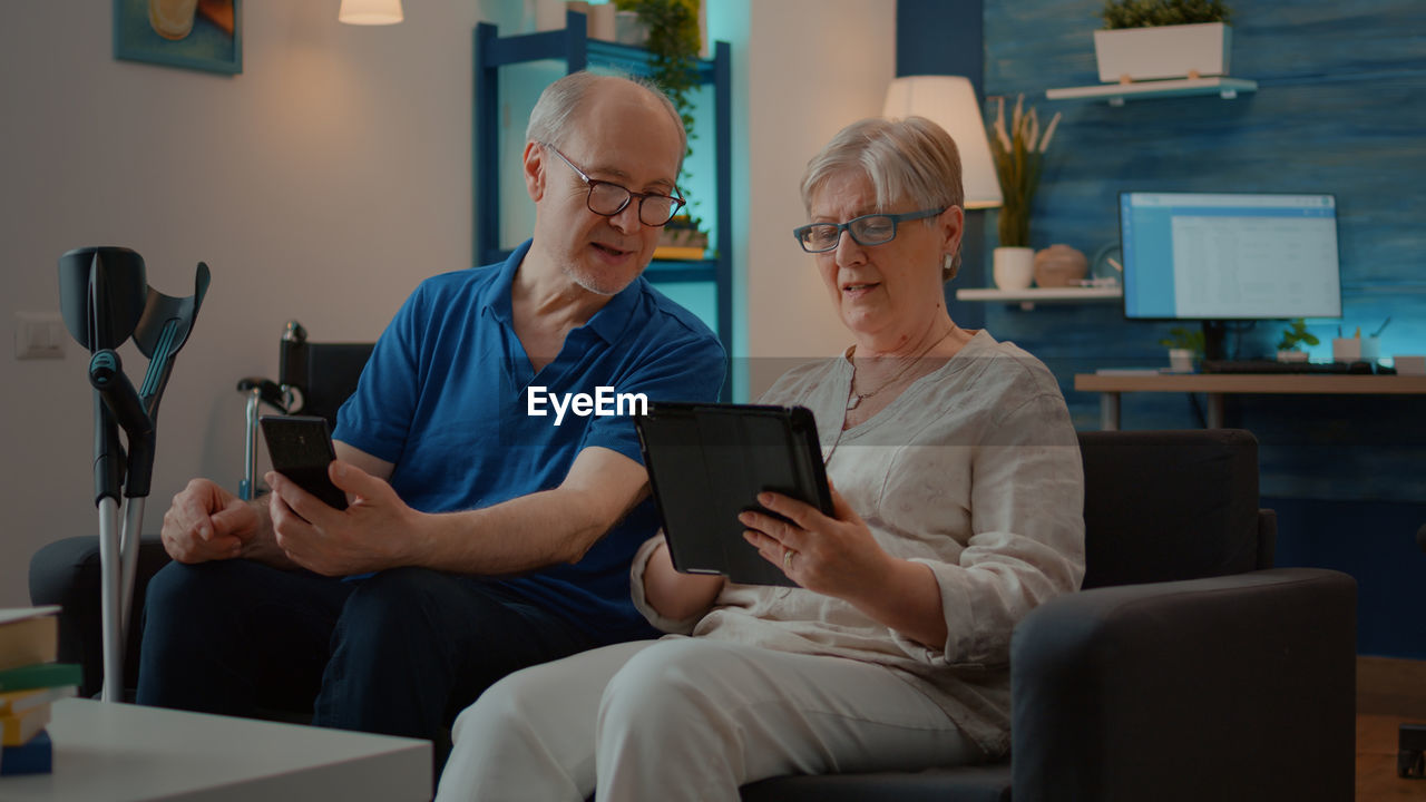 Senior couple looking at digital tablet at home