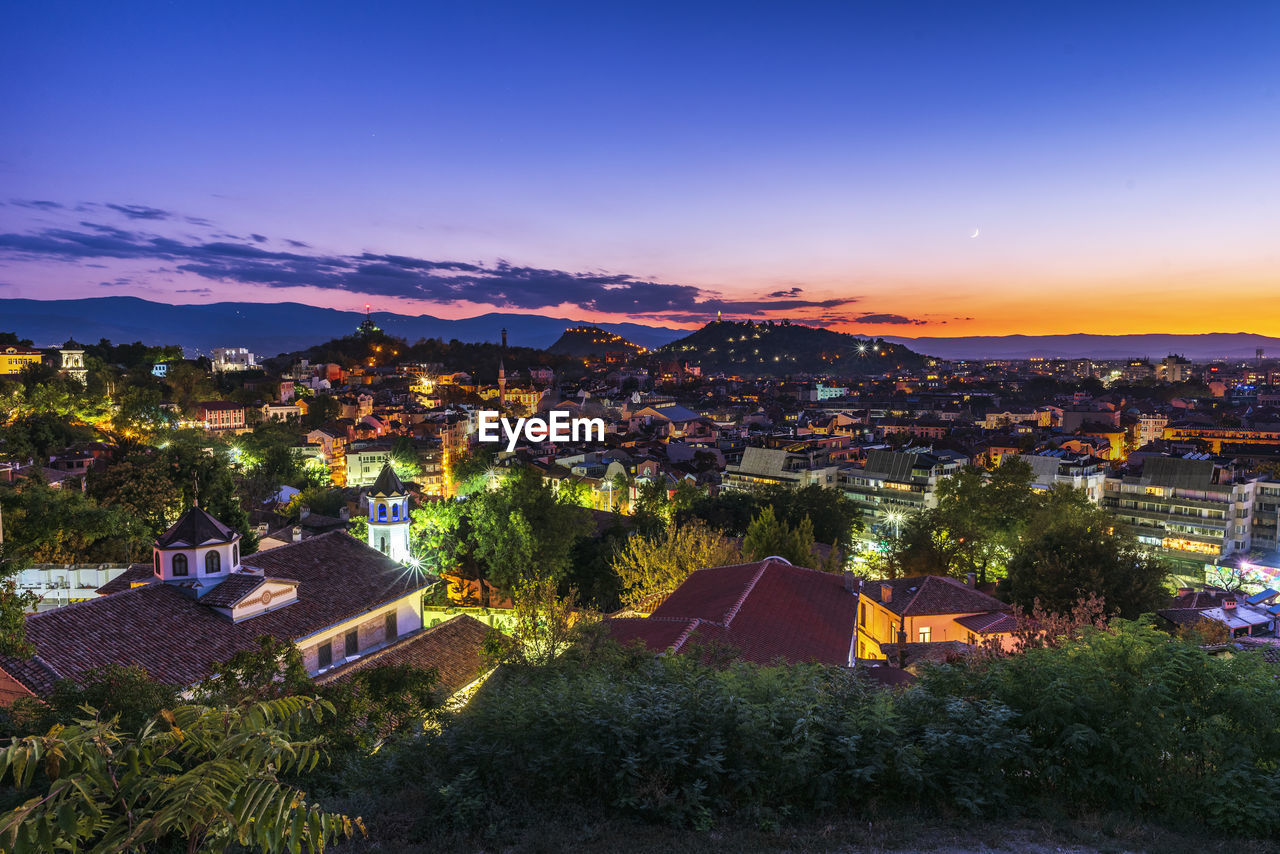 High angle view of illuminated buildings against sky at sunset