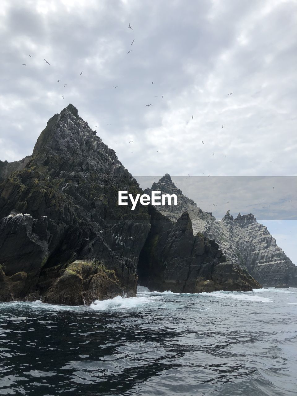 Rock formation in sea against sky