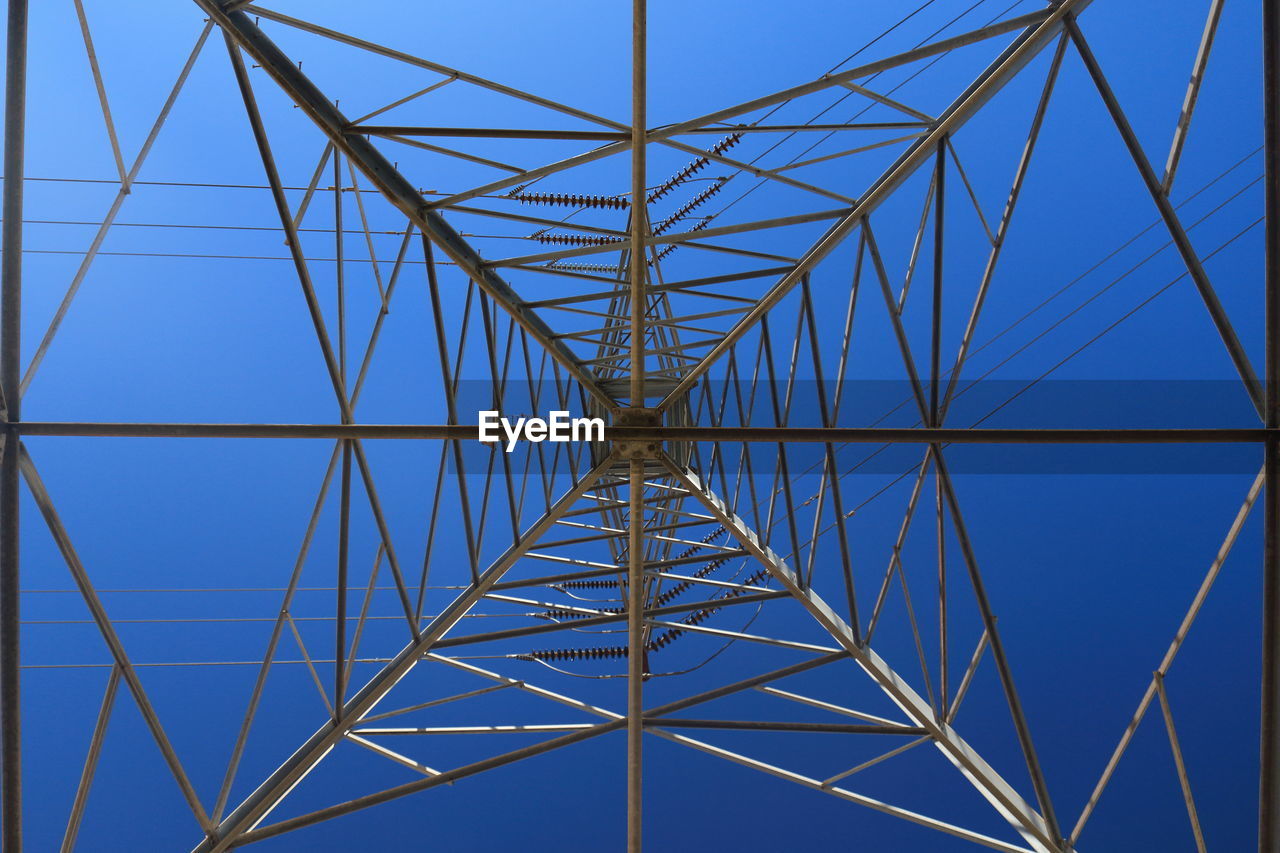 LOW ANGLE VIEW OF ELECTRICITY PYLONS AGAINST CLEAR BLUE SKY