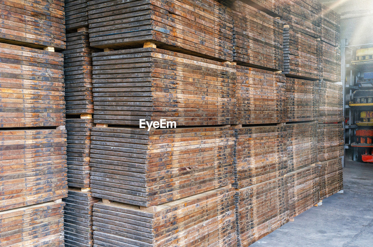 Stacks of wooden pallets. interior of production warehouse. plant for production of paving slabs.