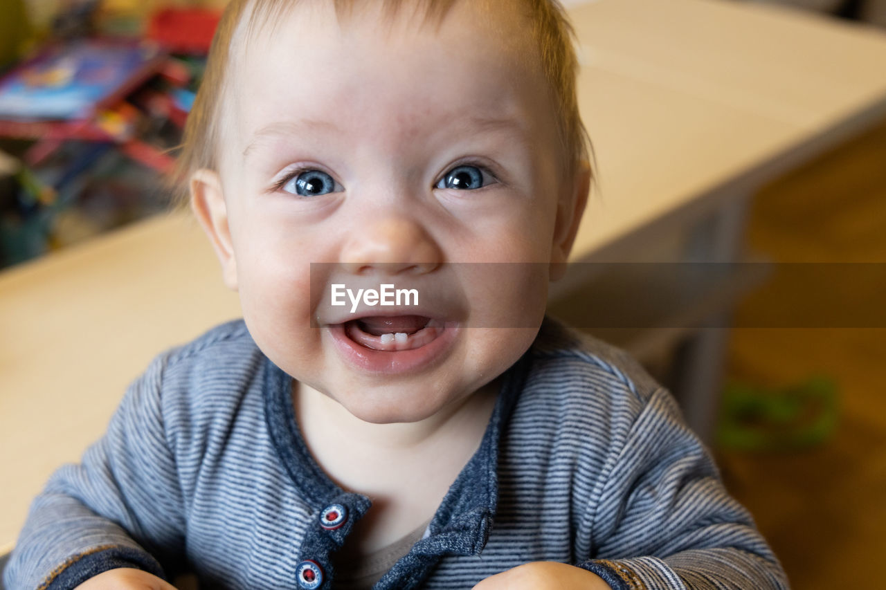 Cute baby with blue eyes is learning how to walk. high quality photo