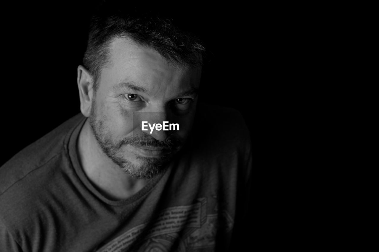 Portrait of mature man against black background