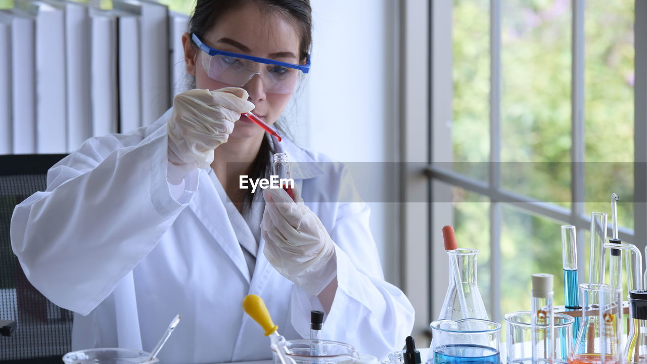 Scientist working while sitting by window in laboratory