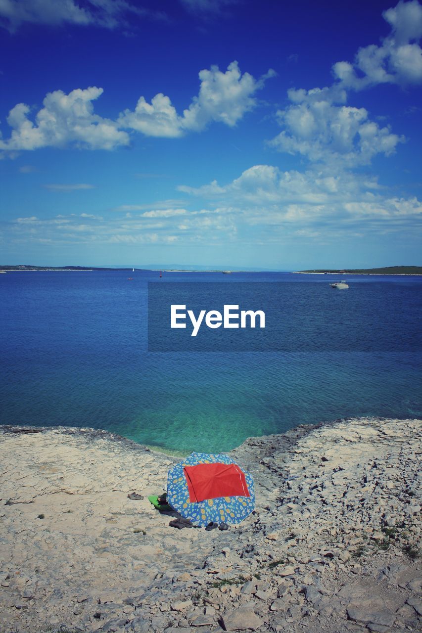 Scenic view of sea against sky with single umbrella 