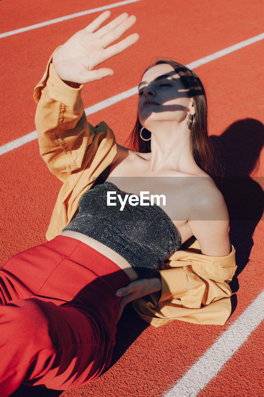 High angle view of woman lying down on running track