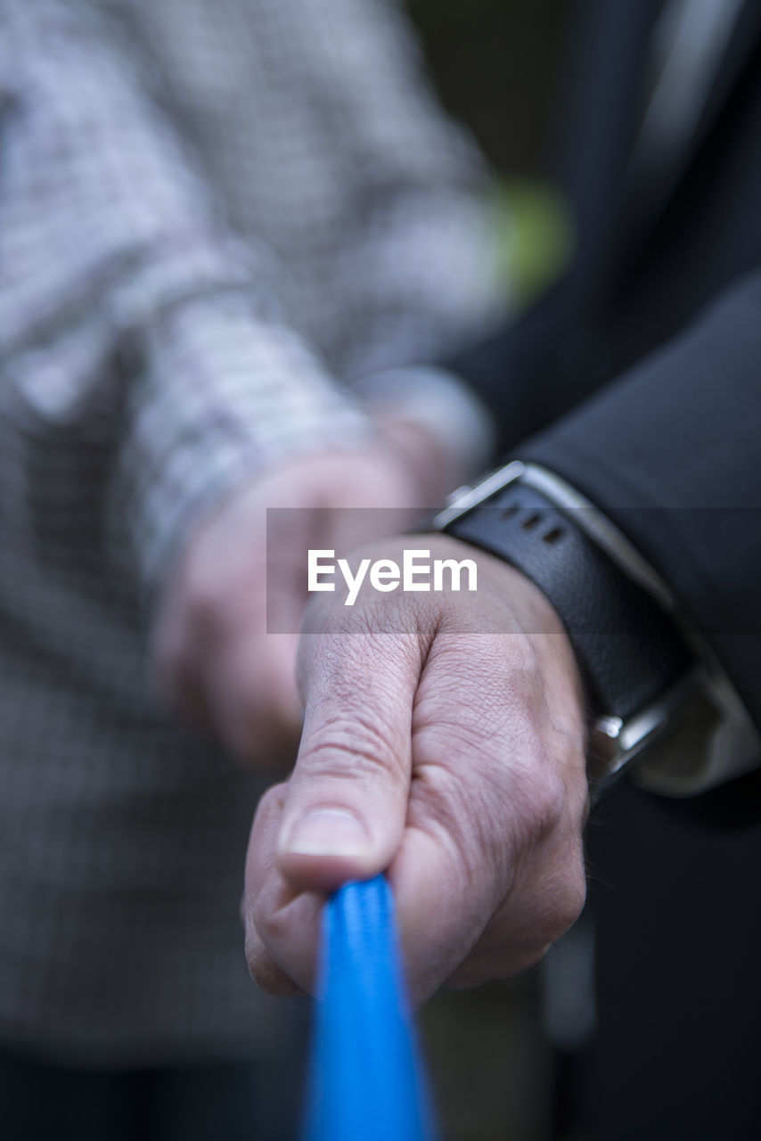 CLOSE-UP OF MAN HOLDING CIGARETTE