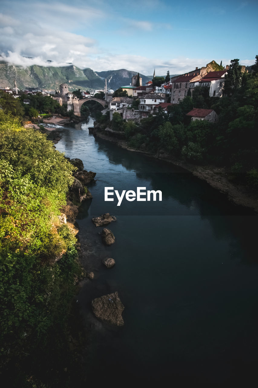 High angle view of river amidst buildings against sky