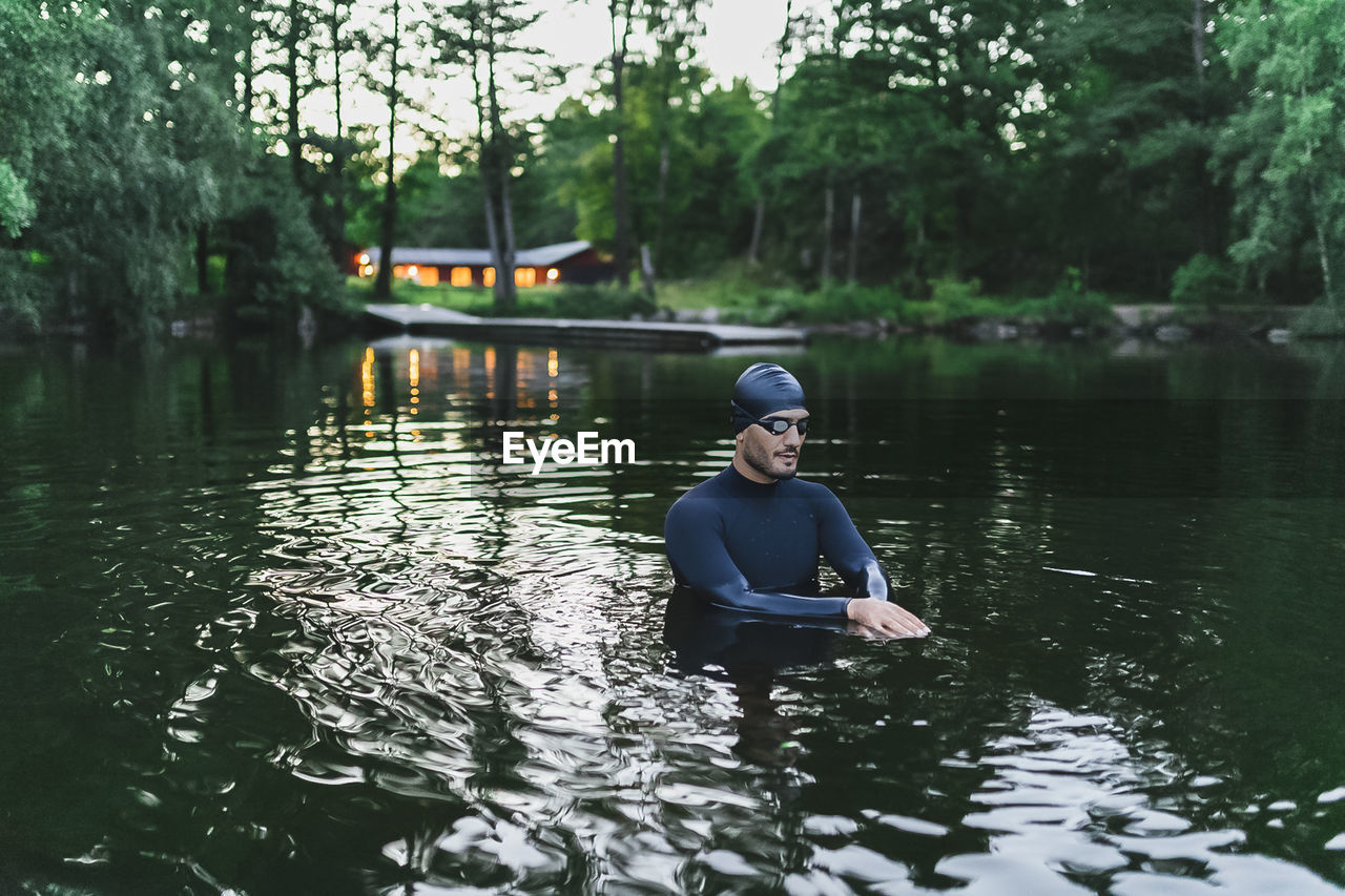 Man doing warm up exercises standing in lake