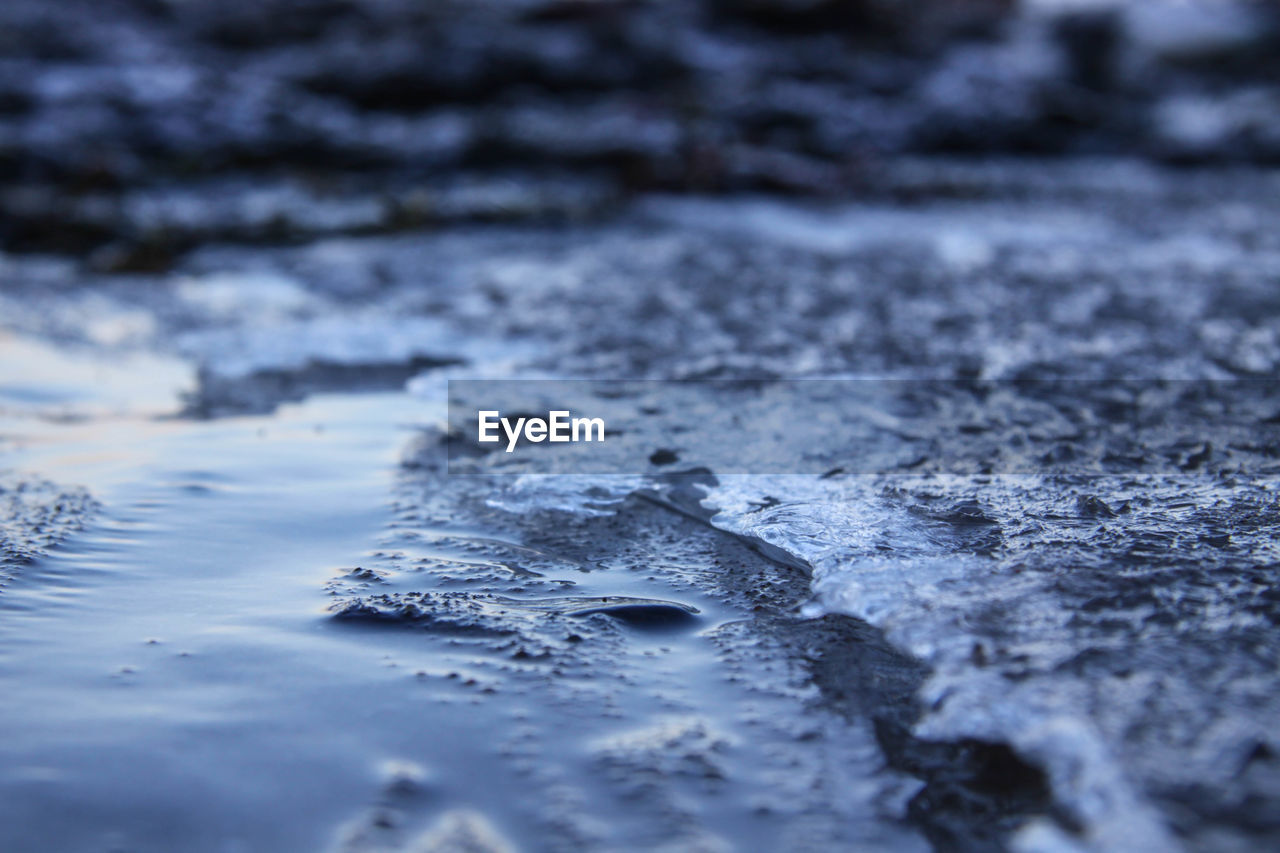 CLOSE-UP OF FROZEN WATER IN WINTER