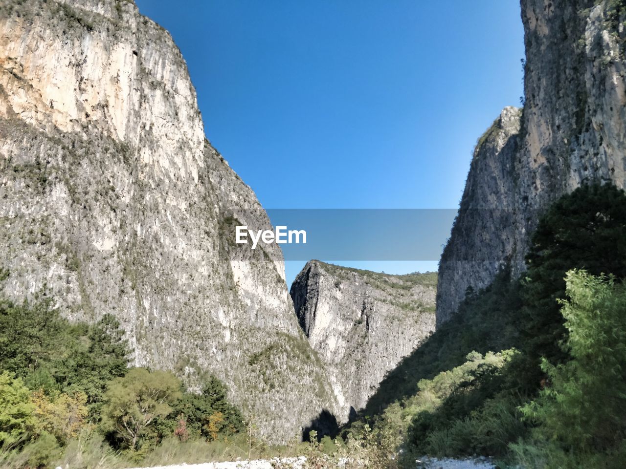 Low angle view of rock formation against clear blue sky