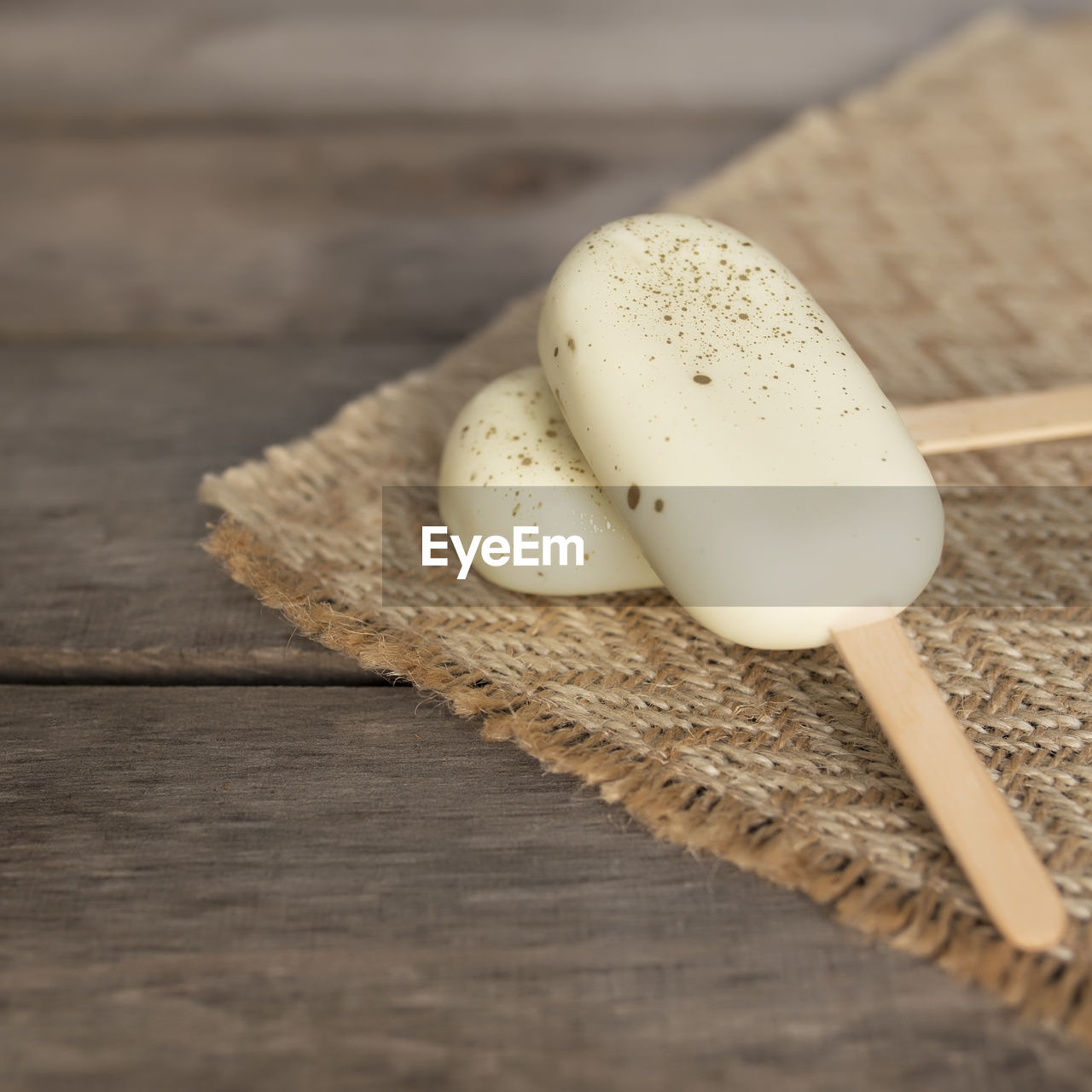 White shiny cookie ice creams on a stick on wooden background. high quality photo