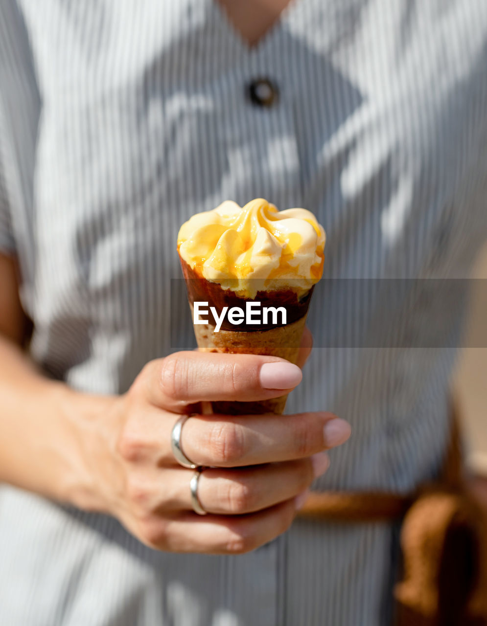 Woman hand holding ice cream cone outdoors