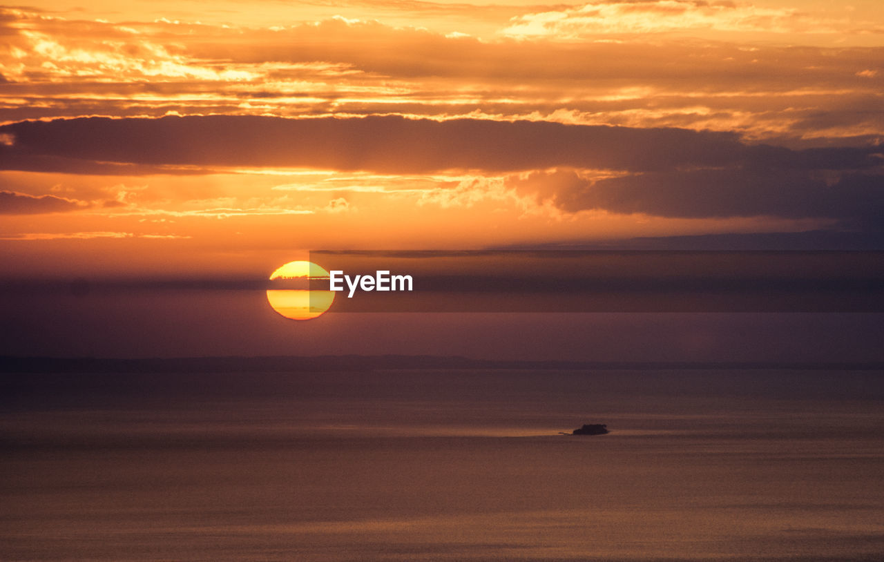 Scenic view of sea against romantic sky at sunset