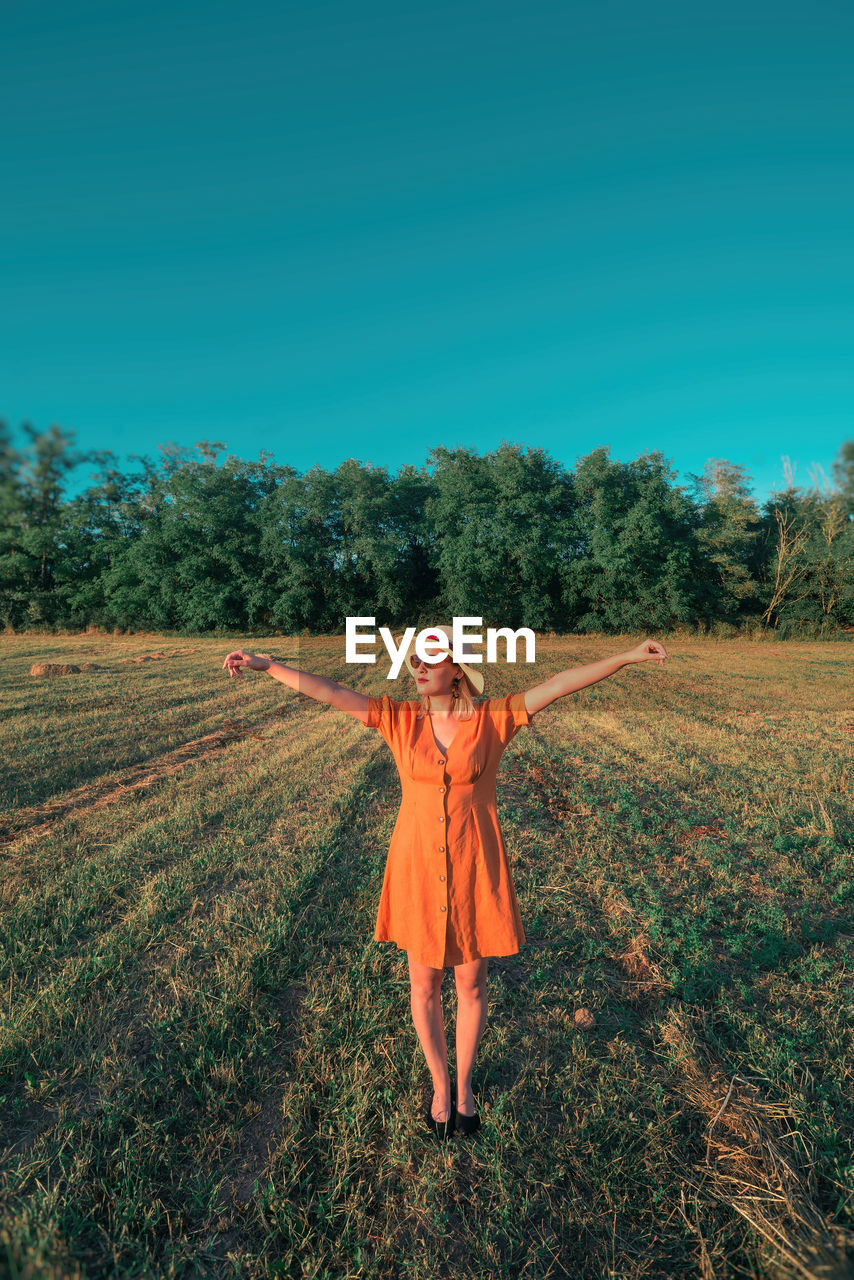 Woman with arms outstretched standing on land