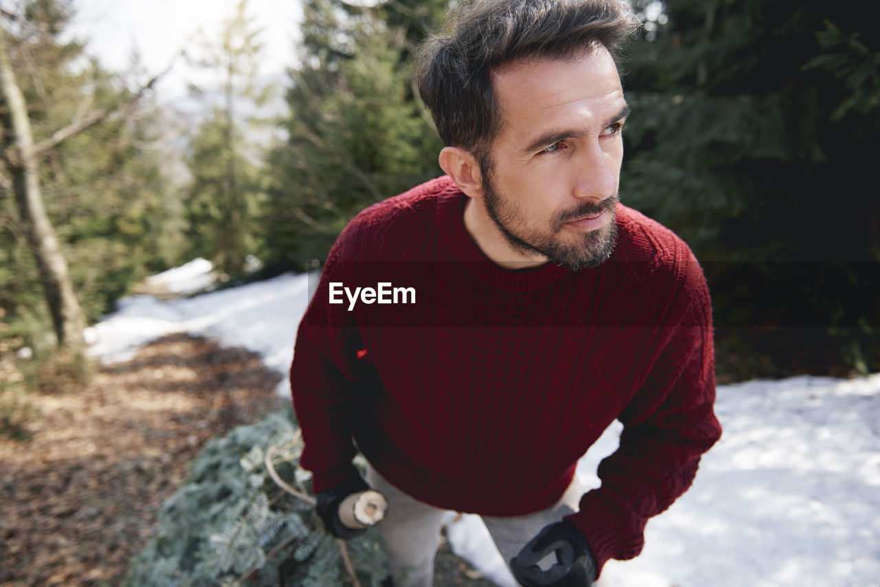 Mature man with branch on snowy land