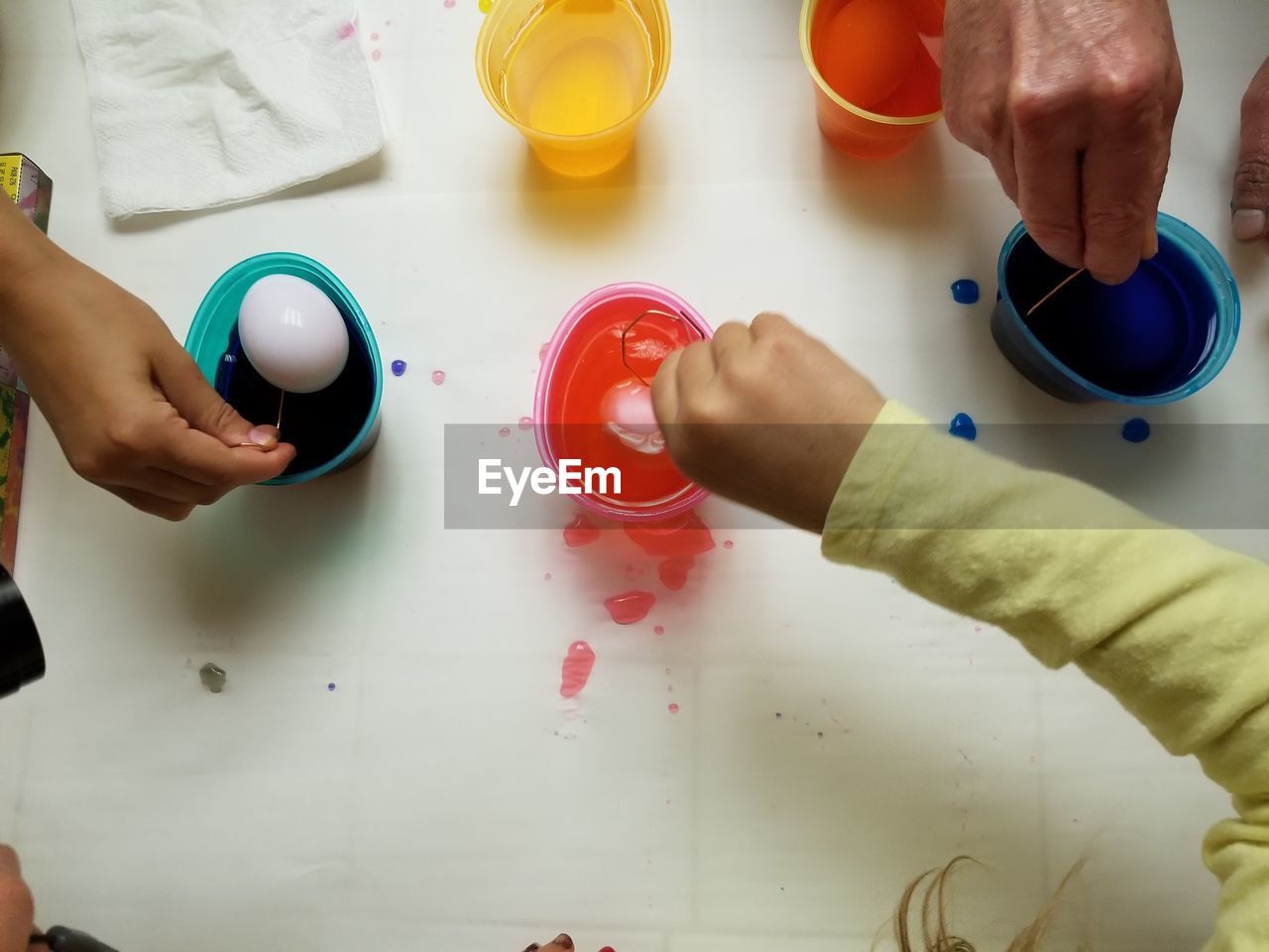 Cropped hands coloring easter eggs
