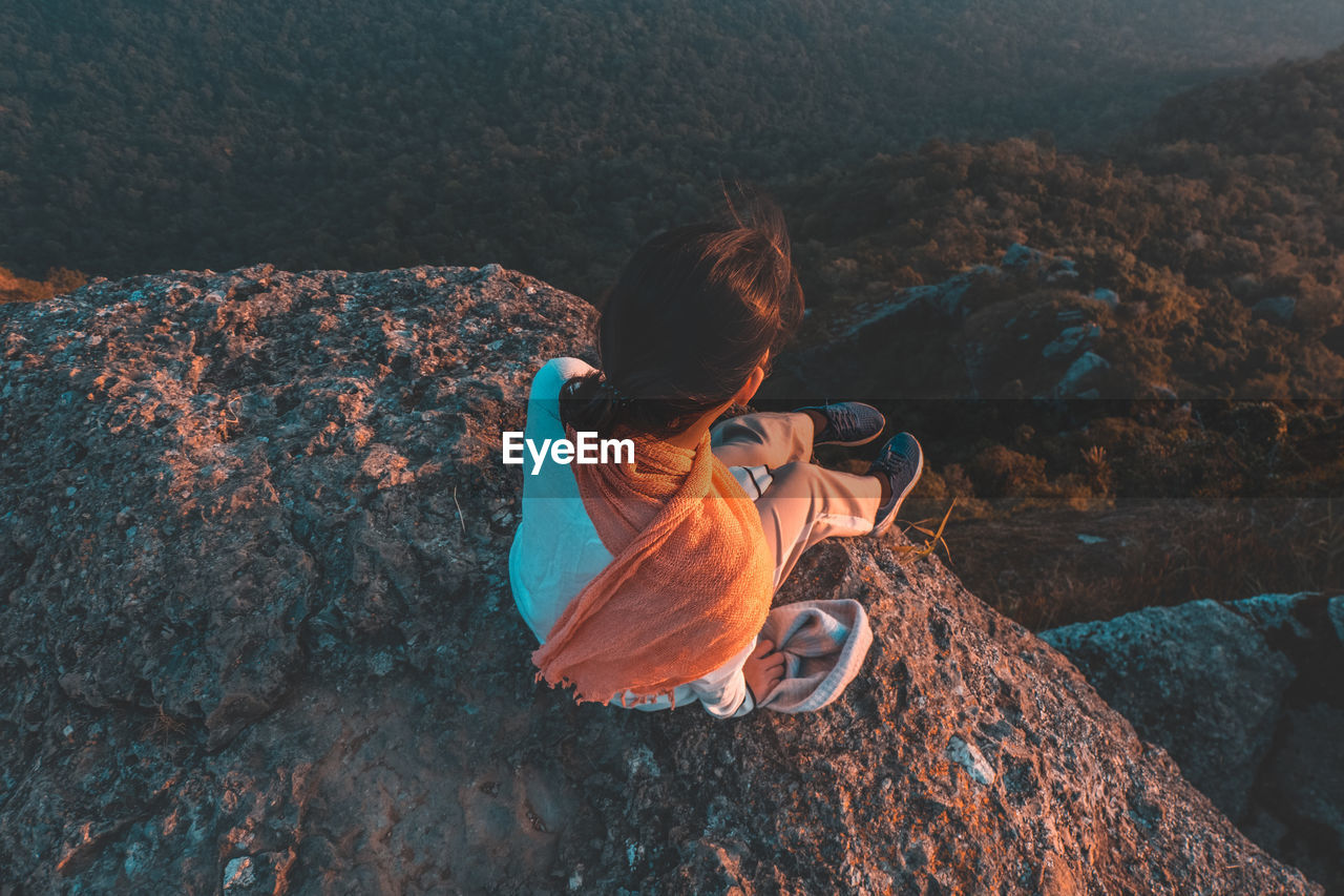 High angle view of woman sitting on rock