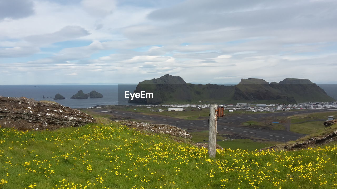 Scenic view of mountain range against cloudy sky