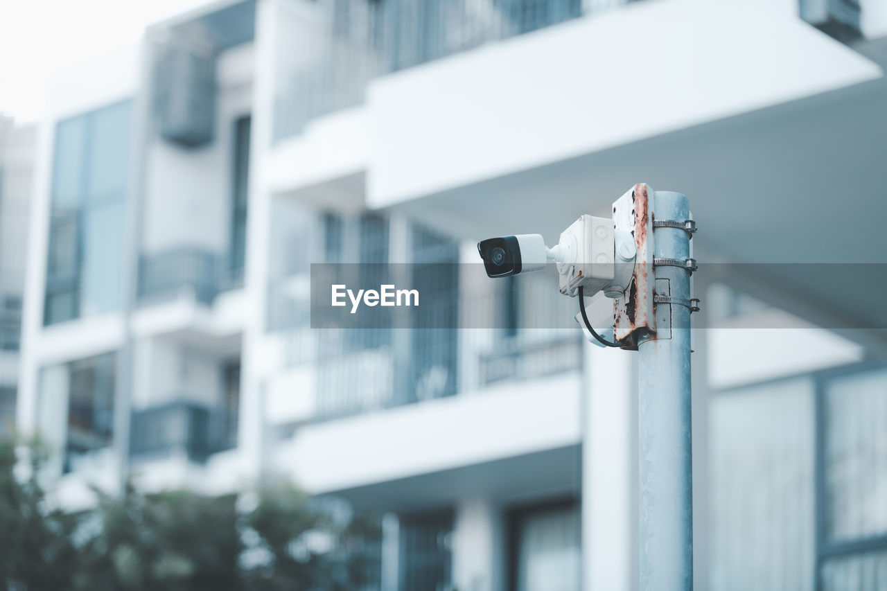 Cctv. video surveillance camera is mounted on a pole outside an apartment