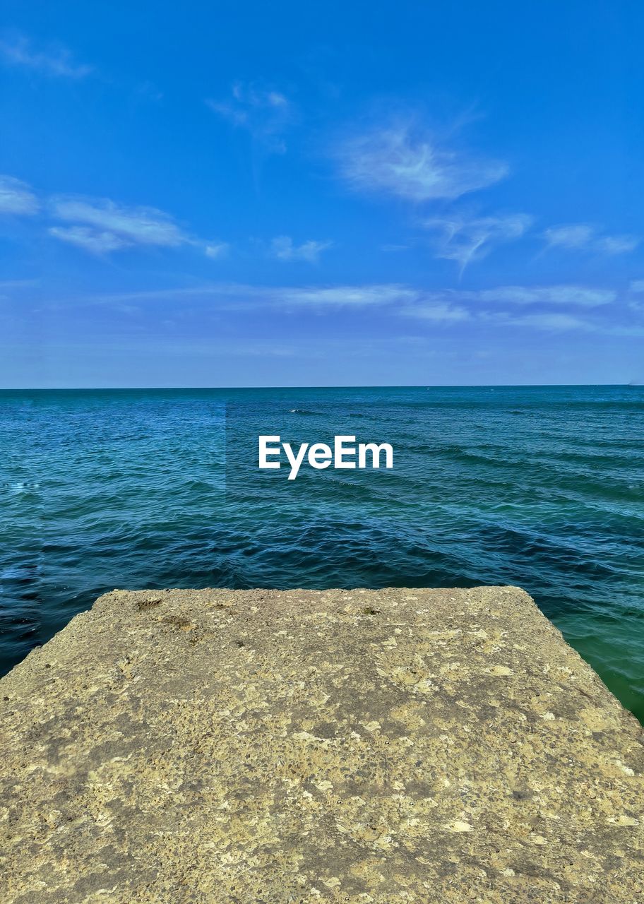 water, sea, horizon, sky, shore, horizon over water, beauty in nature, scenics - nature, ocean, land, beach, nature, blue, body of water, tranquility, coast, tranquil scene, no people, cloud, rock, sand, bay, day, idyllic, travel destinations, outdoors, seascape, travel, wave, sunlight, holiday, summer, urban skyline, vacation, trip, tropical climate, environment, tourism, azure, sunny
