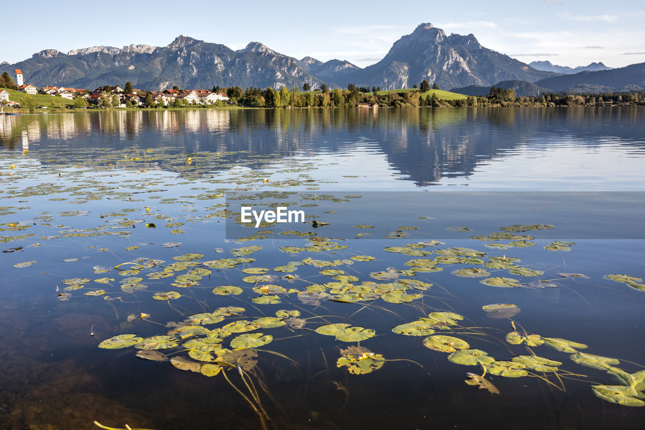 Scenic view of lake by mountains against sky