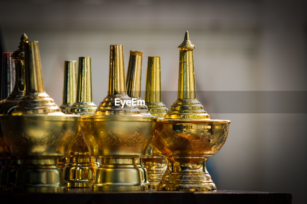 Close-up of gold colored perfume sprinklers